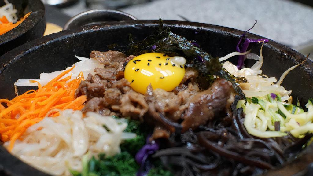 Dolsot Bibimbap · Assorted vegetables served over rice crisped over the fire with a fried egg .