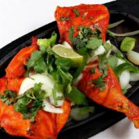 Tandoori Chicken · Chicken marinated in yogurt, ginger and garlic, then roasted in our clay oven.