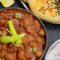Amritsari Chole Kulche  · Chick peas cooked in a rich gravy of onions and tomatoes tempered with Amritsari spices. Ser...