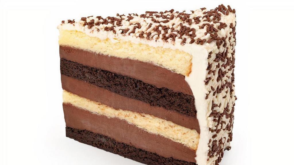 Black & White Fudge Cake Slice · Alternating layers of Buddy’s original vanilla & chocolate cake, filled with our homemade chocolate fudge icing, topped with velvety vanilla buttercream