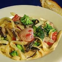 Fettuccine Alfredo · Fettuccine noodles in a light alfredo sauce with shiitake mushrooms, broccoli, diced tomatoe...