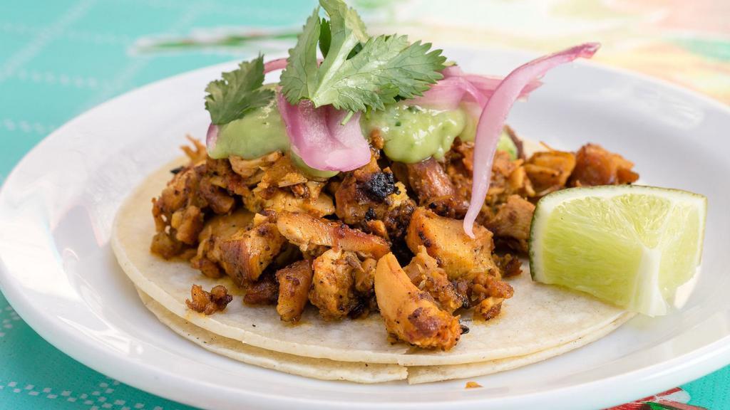 Pollo · Grilled achiote-marinated chicken thighs, avocado salsa, pickled red onions and cilantro.
