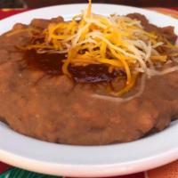 Re-Fried Pinto Beans · With salsa ranchera and cheese.