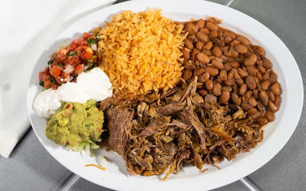 Carnitas Platter · Braised and shredded pork seasoned, accompanied by Spanish rice, beans, sour cream, salsa fresca, guacamole and your choice of tortillas.