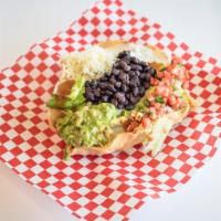 Taco Salad · Served on a bed of beans, crispy tortillas, lettuce, enchilada sauce, guacamole, corn, sour ...