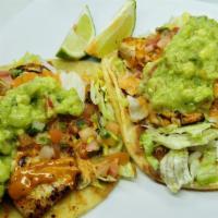 2 House Fish Tacos · Grilled tilapia seasoned with Chile-Lime over corn tortillas with Refried beans spread, Shre...