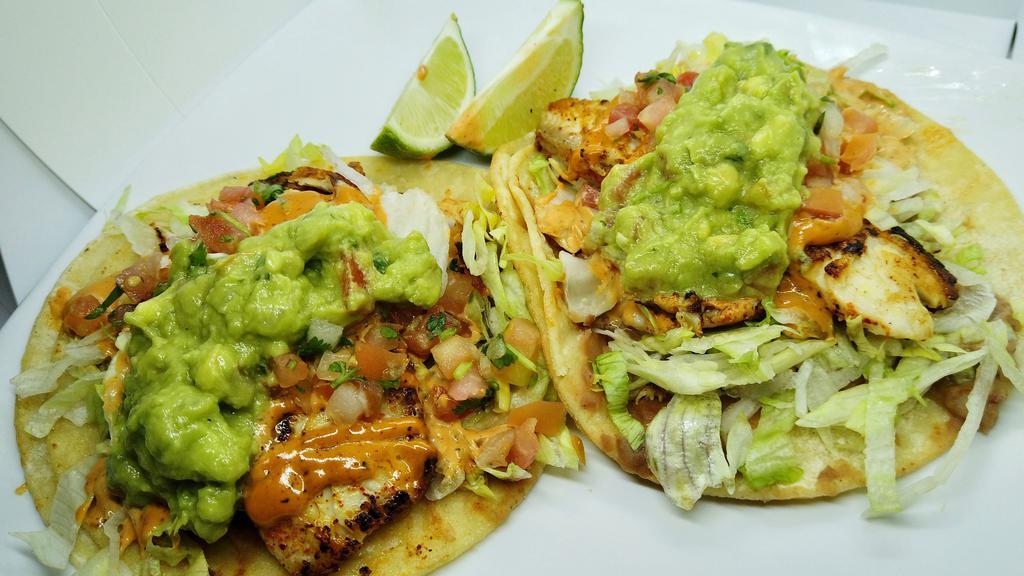 2 House Fish Tacos · Grilled tilapia seasoned with Chile-Lime over corn tortillas with Refried beans spread, Shredded Lettuce topped off with Chipotle Aioli, Salsa Fresca & Guacamole