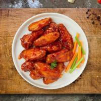 Brawny Buffalo Wings · Fresh chicken wings breaded, fried until golden brown, and tossed in buffalo sauce. Served w...