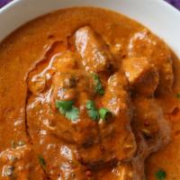 Chicken Curry · Chicken stewed in an onion and tomato-based sauce. Garnished with cilantro.