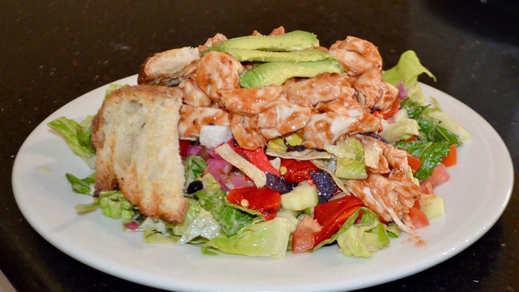 BBQ Chicken Salad · Roasted chicken served over mixed greens tossed in BBQ ranch dressing with peppers, black beans, corn avocado, crispy noodles, cucumber and tomato.