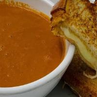Grilled Cheese and Tomato Soup · Grilled cheese sandwich and a cup of tomato soup, served with fries