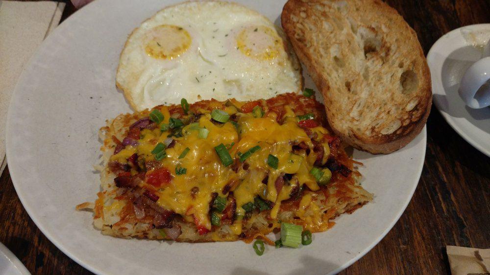 Sunnyside hash · Topped with bacon, red onion, bell pepper, cherry pepper, mushroom, scallion, and mild cheddar. Served with two eggs and toast.