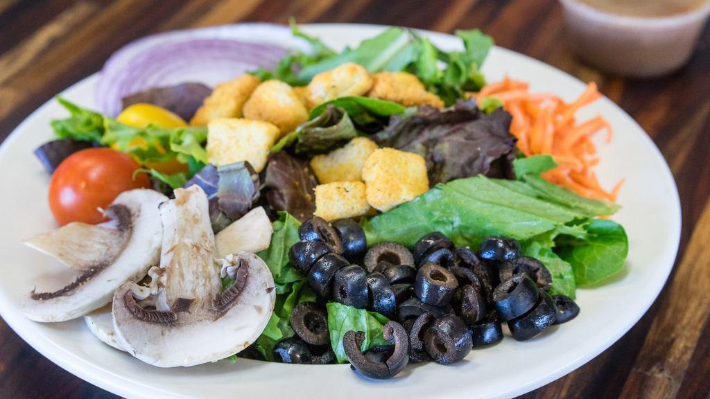 Roma Salad · Mixed organic greens, spinach, romaine, red onions, shredded carrots, olives, mushrooms, cherry tomato, croutons, and choice of dressing.