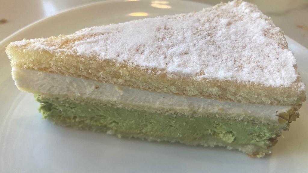 RICOTTA & PISTACHIO CAKE · Ricotta & pistachio creams separated by sponge cake, decorated with crushed pistachios & dusted with powdered sugar.