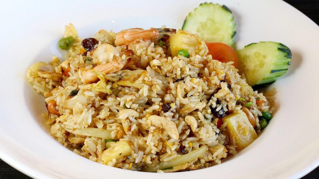 Pineapple Fried Rice · Fried rice with chicken & prawns, egg, peas, carrot, pineapple, raisins, cashew nuts, onion, curry powder and green onion.