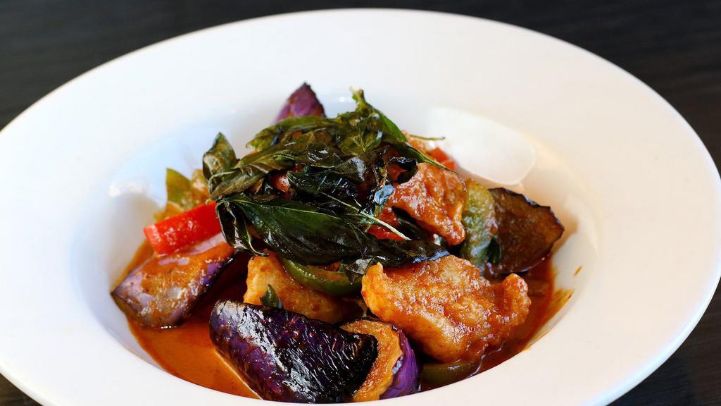 Spicy Catfish · Crispy catfish wok tossed with eggplant, bell peppers and kaffir lime leaves, wild ginger in red curry coconut sauce topped with crispy basil served with white rice.