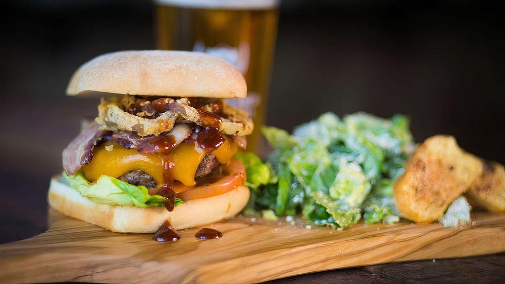 Cowboy Burger · Applewood-smoked bacon, cheddar cheese, onion rings, BBQ sauce, garlic aioli, lettuce, tomato.