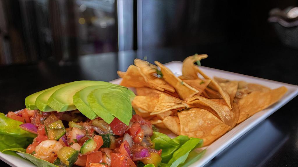 Ceviche · Grilled shrimp ceviche with diced cucumber, tomato, red onion, and cilantro all tossed in a house made sauce. Served with avocado and tortilla chips.