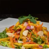 Thai Mango Salad · Shredded sweet mangos, red onion, green onion, cilantro, baked coconut flakes, and toasted a...