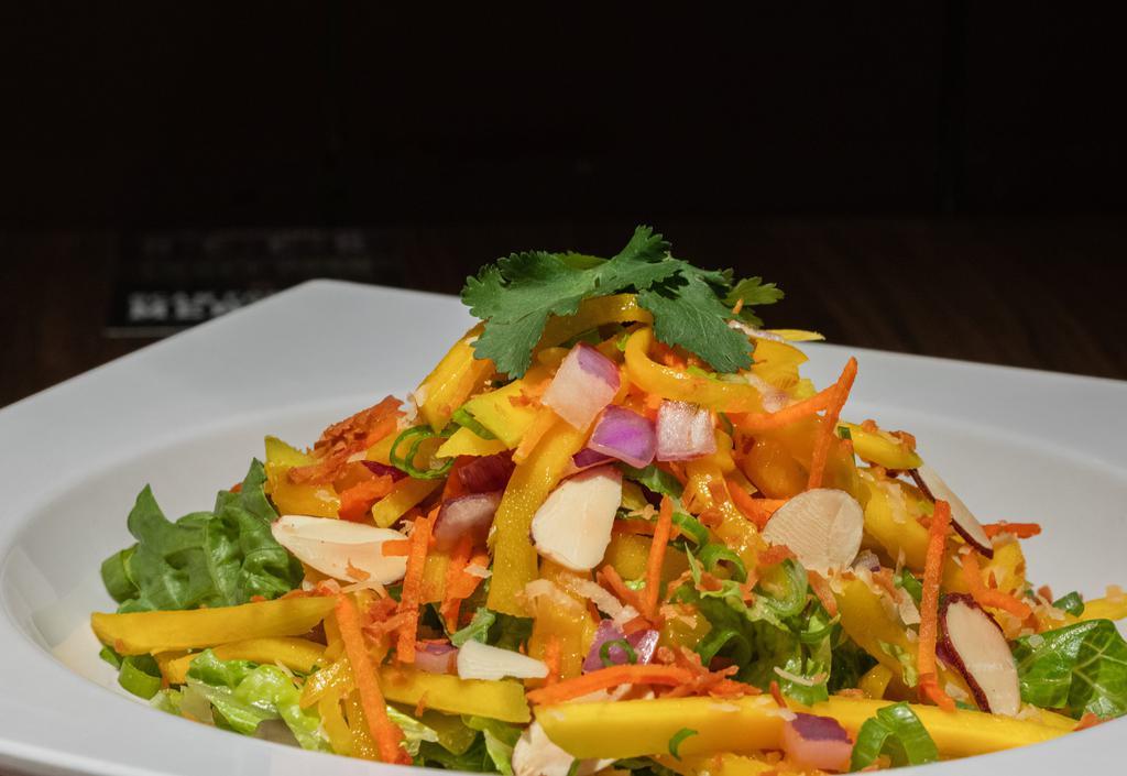 Thai Mango Salad · Shredded sweet mangos, red onion, green onion, cilantro, baked coconut flakes, and toasted almonds, in a citrus Thai vinaigrette