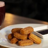 Churro Bites · Mini churros tossed in cinnamon and sugar, served with warm chocolate dipping sauce.
