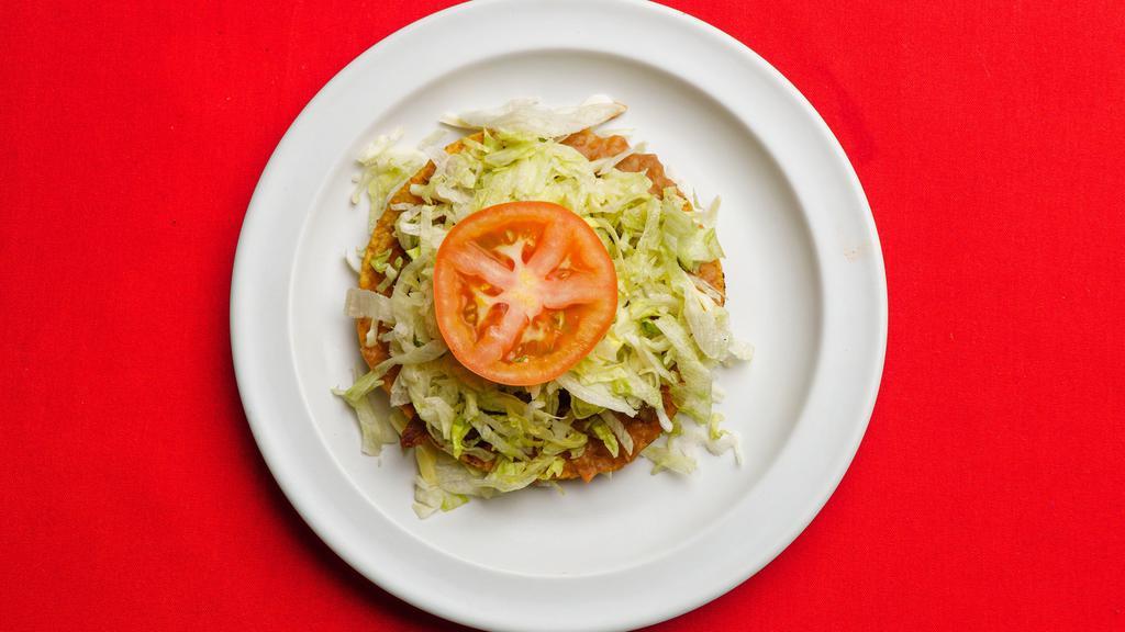 Corn Tostada · Tortilla shell with choice of meat, re-fried beans, lettuce, guacamole,cheese and sour cream.