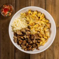 Carnitas Breakfast Bowl · A bowl filled with carnitas, potatoes, fluffy scrambled eggs, cheese, and a side of salsa.