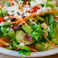 Chop Salad · Romaine hearts, carrots, tomatoes, English cucumbers, goat cheese and bacon. Tossed with hou...