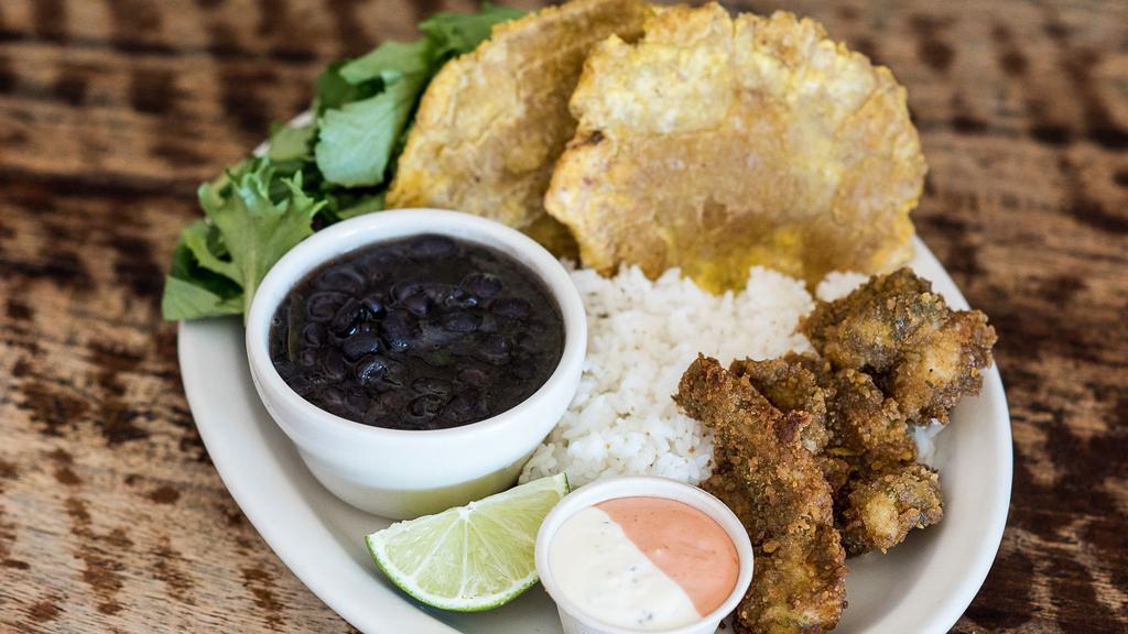 Camarones Empanizados · Plantain-fried prawns served with salad, rice, beans, plantains, fresh lime, and sauce for dipping.