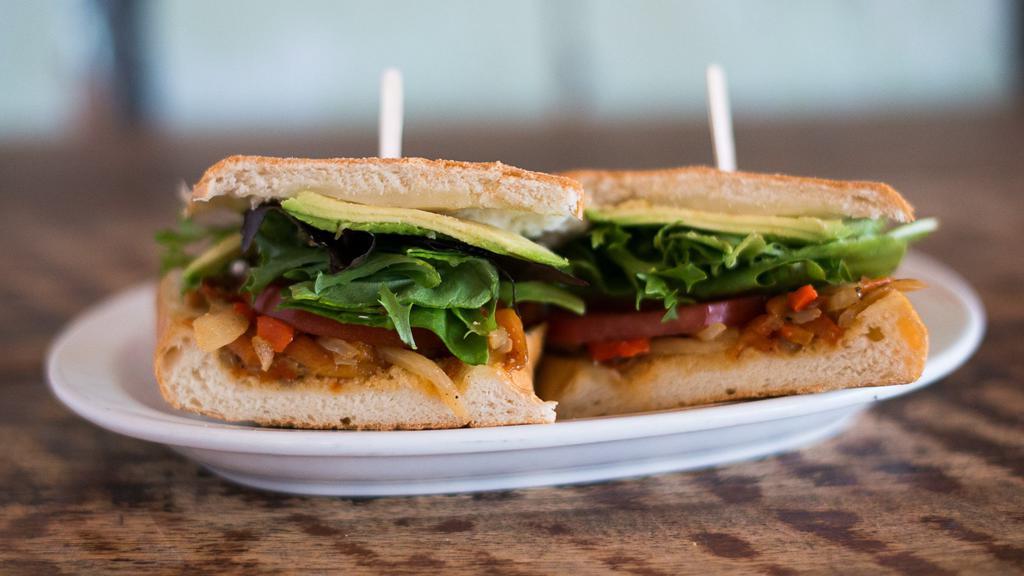 Veggie Deluxe · Avocado, roasted peppers, sautéed onions, organic greens, tomato, jack cheese, and cilantro-lime mayo on French bread.