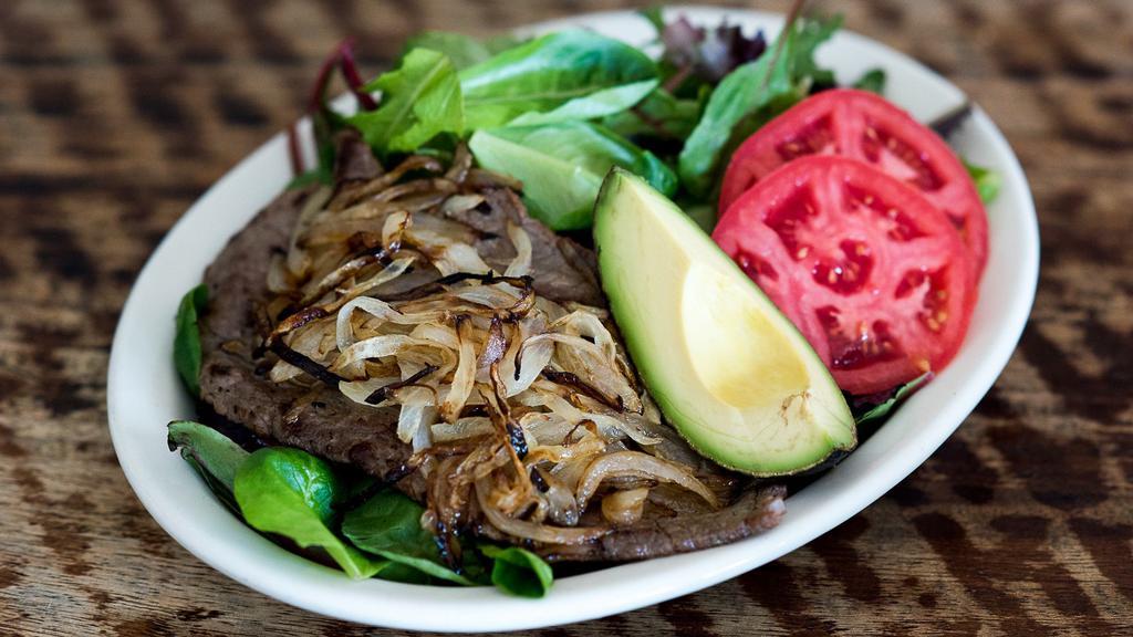Ensalada con Bistec · Steak with sautéed onions and tomatoes served on organic greens with lemon dressing.