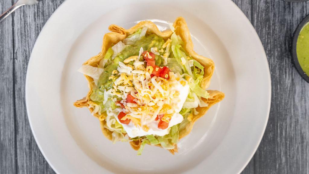 Taco Salad · Served on a flour tortilla shell with rice, beans, lettuce, tomato, cheese, sour cream, guacamole and choice of meat.