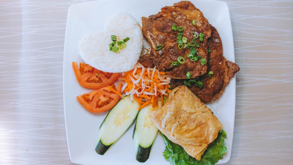 25. Cơm Sườn Nướng & Tàu Hủ Ky · Grilled bone-in pork chop, and fried shrimp cake served with steamed rice.