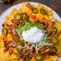 Supper Nachos · Tortilla chips overloaded with cheese, pico de gallo, pickled jalapeños, refried beans, sour...