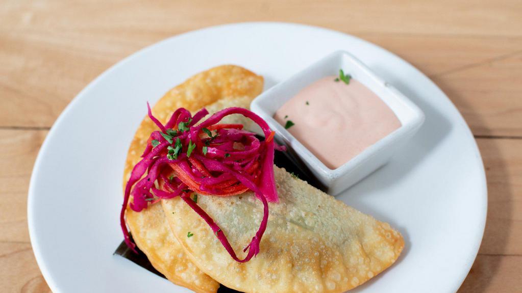*Veggie Empanadas · savory crispy pastries filled with mixed vegetables; served with our popular spicy sriracha aioli (3 pieces)