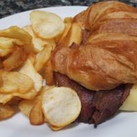 Breakfast Croissant Sandwich · Sliced ham, two scrambled eggs and cheese on a  croissant served with country potatoes.