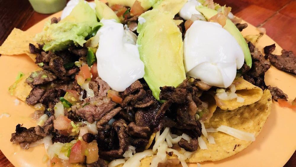 Super Nachos · Crispy chips with your choice of meat, melted cheese, refried beans, sour cream, avocado, and pico de gallo salsa.