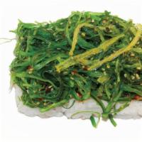 Poki Roll · Spicy tuna roll with seaweed salad on top.