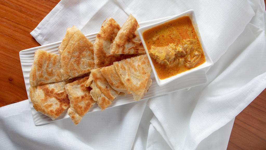 Platha with Coconut Chicken Curry Dip · Multi-layer bread served with coconut chicken curry.