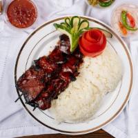 Pork Skewer (3) Over Rice · Two grilled pork skewers over rice slathered with our very own bbq sauce