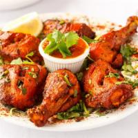 Tandoori Chicken · 3 Leg pieces Tender chicken marinated in yogurt, spices, baked in the tandoor and sauteed in...