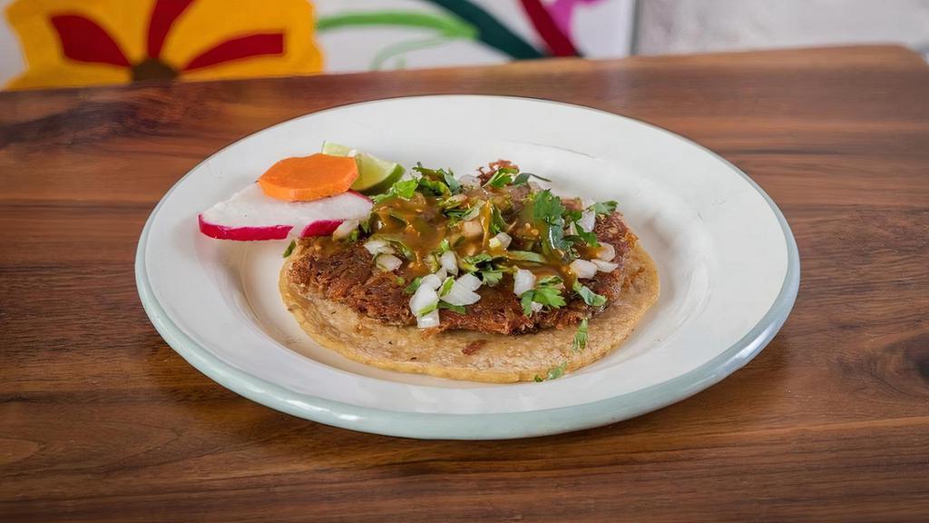 Taco de Carnitas · one crispy fried pork taco topped with  onion, cilantro, salsa
