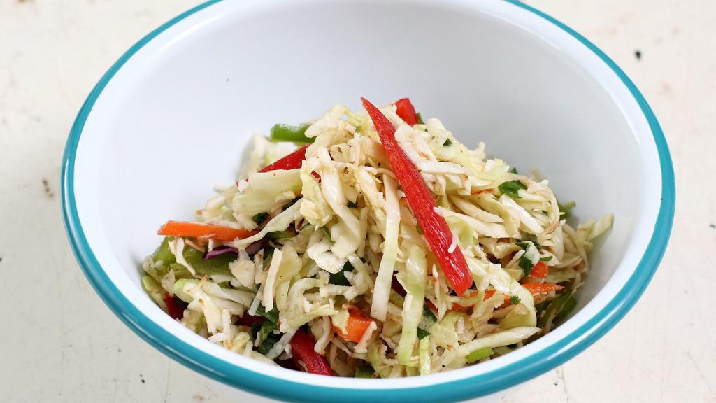 Coconut Slaw · shredded cabbage, bell pepper, toasted coconut, cilantro, and lime.