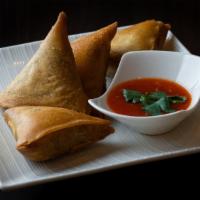 Samosas · Vegetarian. Hand-made wheat flour wraps fried and filled with potatoes, onions, and spices s...