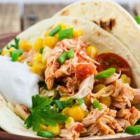 Shredded Chicken Taco · A taco filled with shredded chicken tinga, lettuce, tomatoes, cheese and sauce