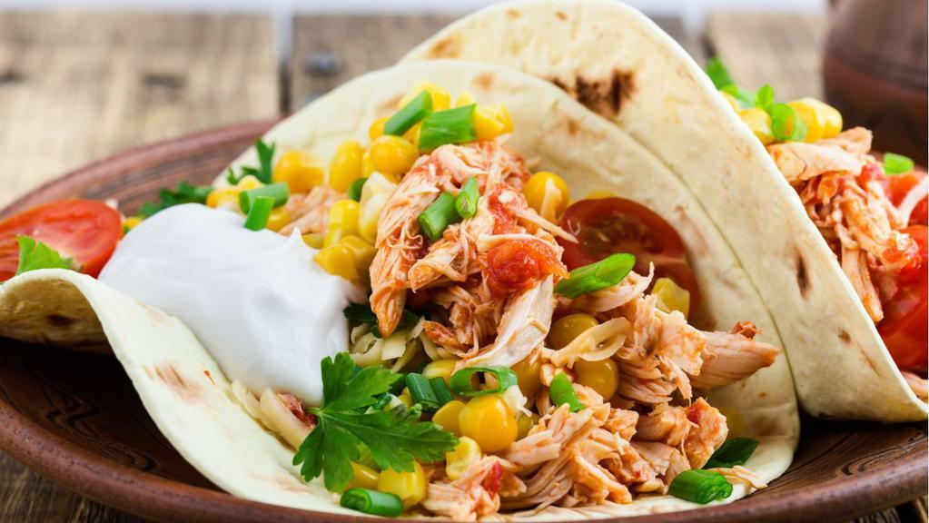 Shredded Chicken Taco · A taco filled with shredded chicken tinga, lettuce, tomatoes, cheese and sauce