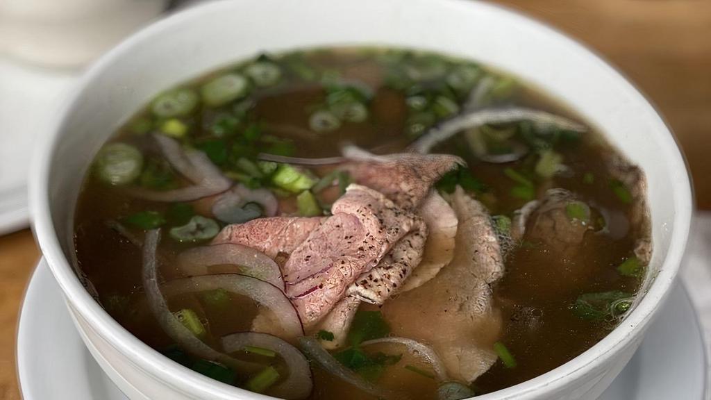 Pho Bo · Rare beef and brisket with rice noodles in beef broth. Finished with Chinese celery, cilantro, scallions, red onions. Garnishes of bean sprouts, lime, jalapeños, thai basil, hoisin and sriracha upon request.