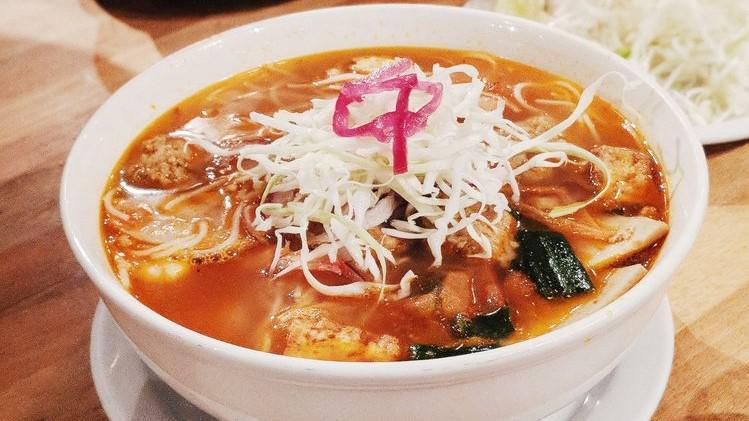 Bun Rieu · crab and minced pork balls, shrimp, pork sausage, fried tofu, tomato, chicken-tomato broth. Garnishes of cabbage, bean sprouts, jalapeños and lime upon request.