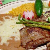 #9 Carne Asada · Two pieces of grilled Carne Asada with a side of guacamole, green onions, and tortillas.