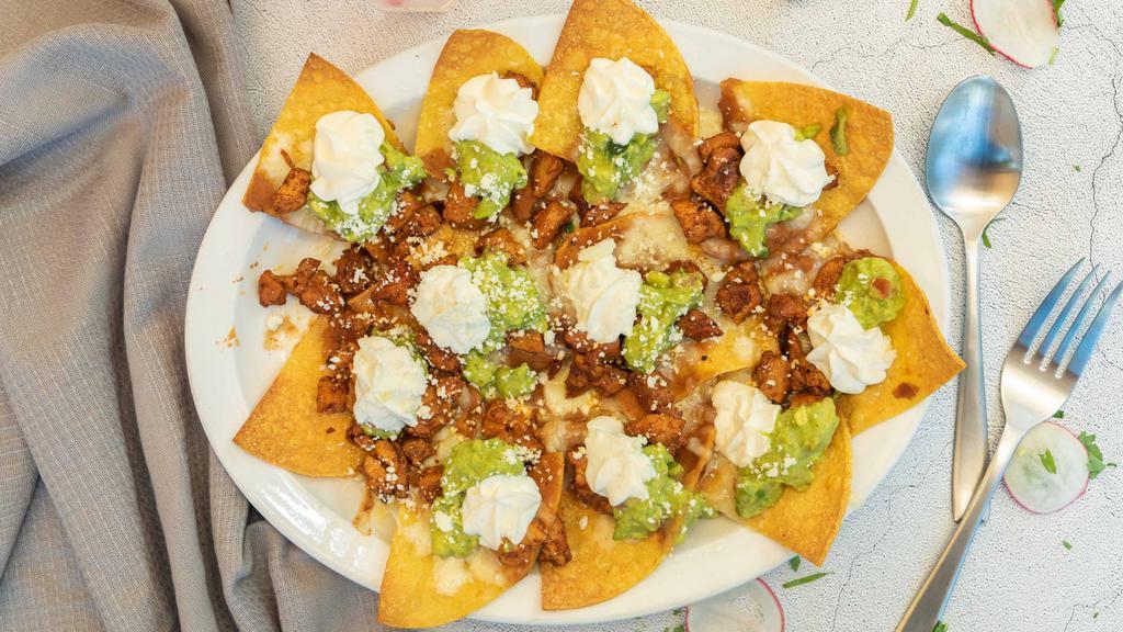 Nachos · Fried corn chips, refried beans, jack cheese, guacamole, sour ream and cotjia cheese.